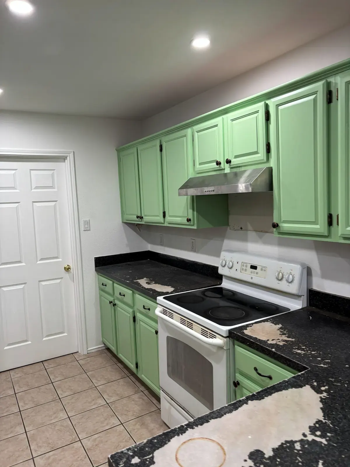 The same kitchen after RGS General Contracting repainted the cabinets in a fresh green finish