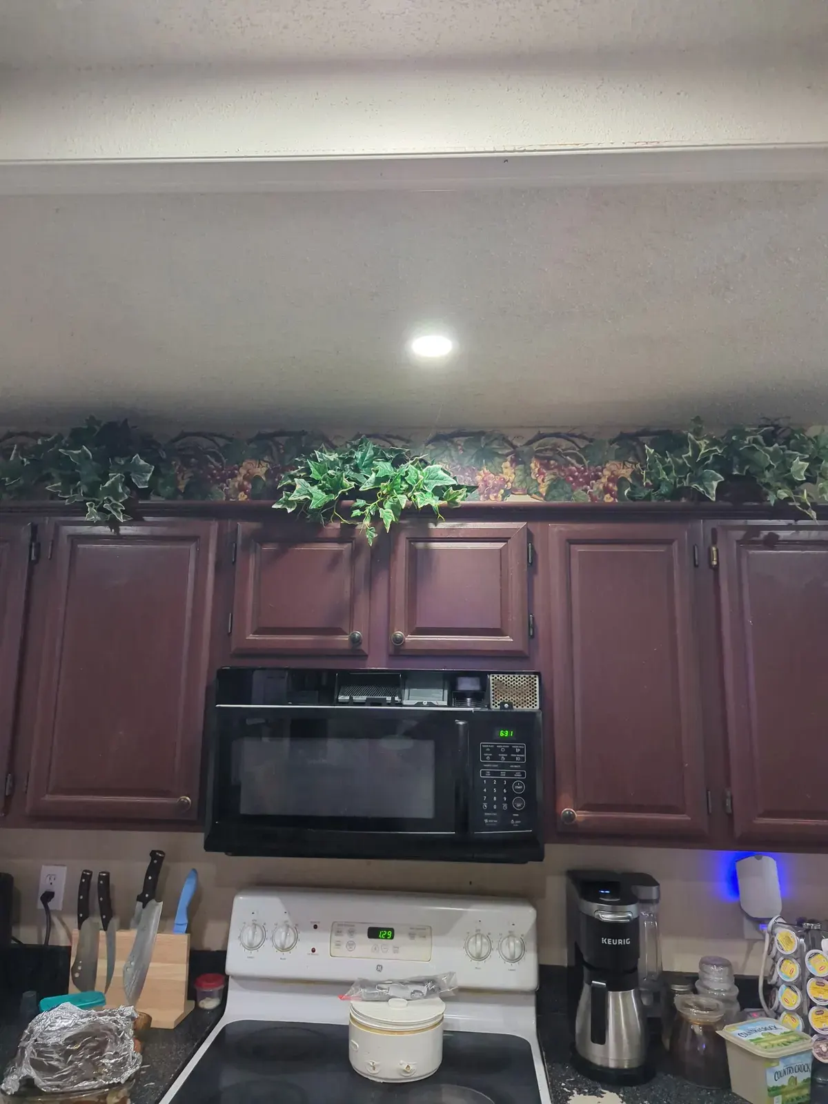 Dated kitchen with dark maroon cabinets before repainting by RGS General Contracting